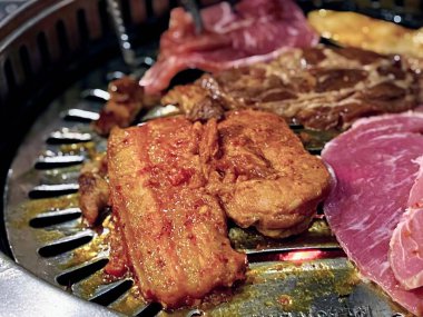 Et ve sebzeli bir ızgaranın fotoğrafı..