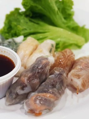 Soslu ve marullu bir tabak yemeğin fotoğrafı..