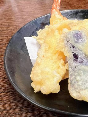 Karides ve patates cipsli bir tabak yemeğin fotoğrafı..