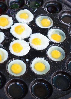 İçinde yumurta olan bir tavanın fotoğrafı..