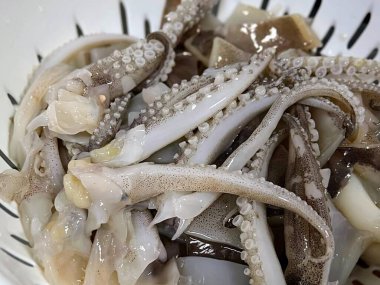 Bir kase kalamar ve çatallı kalamar etinin fotoğrafı..