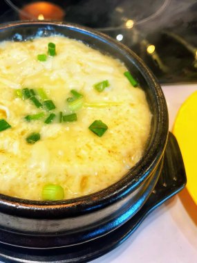 Yeşil soğan ve peynirli bir kase çorbanın fotoğrafı..