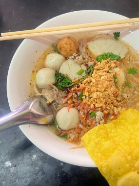 Yemek çubuğu ve ananaslı bir kasenin fotoğrafı..