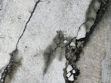 Üzerinde mavi işaret olan kırık bir kaldırımın fotoğrafı..