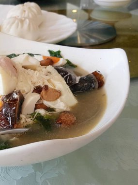 İçinde kaşık olan bir kase çorbanın fotoğrafı..