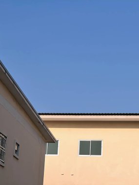 Saat kulesi ve mavi gökyüzü olan bir binanın fotoğrafı..