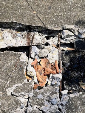 Bir kayanın üzerinde oturan kırık bir oyuncak ayının fotoğrafı..