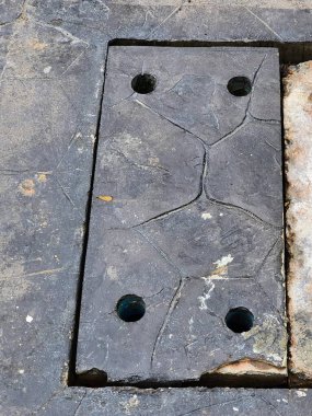 Betonda delikleri olan bir drenajın fotoğrafı..