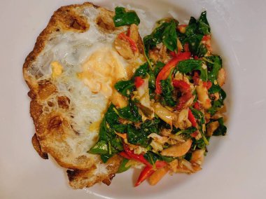 Kızarmış yumurta ve sebzeli bir tabak yemeğin fotoğrafı..