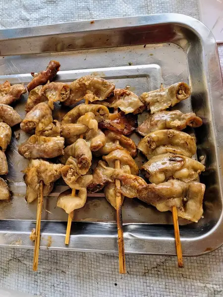 stock image a photography of a tray of chicken skewers on a table.