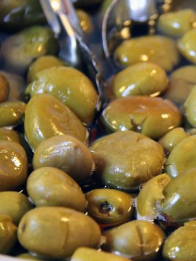 İçinde kaşık olan bir kase zeytin fotoğrafı..