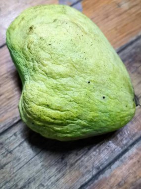 Ahşap bir masada yeşil bir meyvenin fotoğrafı..