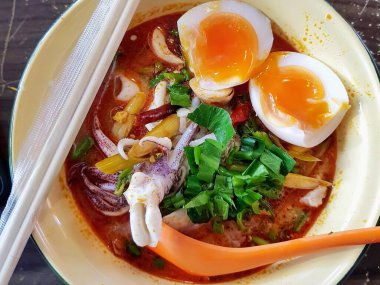 Kaynamış yumurta ve sebzeli bir kase çorbanın fotoğrafı..