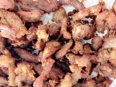 Beyaz bir tabağın üzerinde oturan domuz pastırmasının fotoğrafı..