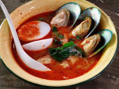 İçinde kaşık ve kaşık olan bir çorba kasesinin fotoğrafı..