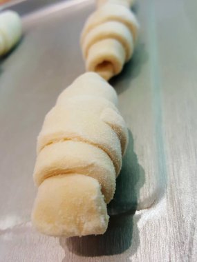 Üzerinde bir sürü çörek olan metal bir tepsinin fotoğrafı..