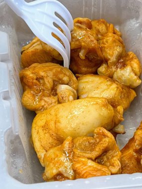 Tavuk ve patatesle dolu plastik bir kabın fotoğrafı..