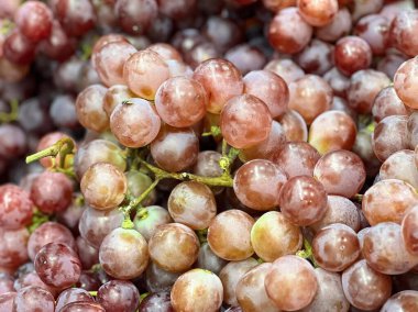 Bir masanın üzerinde oturan bir demet üzümün fotoğrafı..