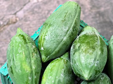 Kaldırımda oturan bir sepet salatalığın fotoğrafı..