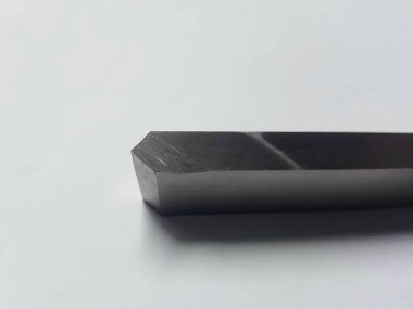 Beyaz bir yüzey üzerinde siyah metal bir nesnenin fotoğrafı.