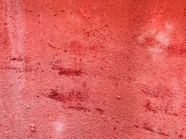 Üzerinde bir sürü leke olan kırmızı bir duvarın fotoğrafı..