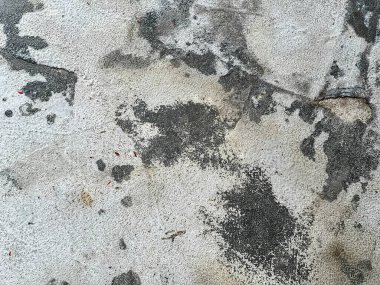 Ortasında yangın musluğu olan kirli bir duvarın fotoğrafı..