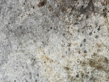 Ortasında küçük bir delik olan kirli bir beton duvarın fotoğrafı..