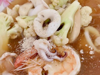 Bir kase karides, brokoli ve karnabaharlı çorbanın fotoğrafı..