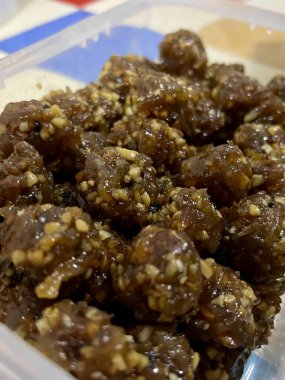 Fındıkla kaplı köftelerle dolu plastik bir konteynırın fotoğrafı..