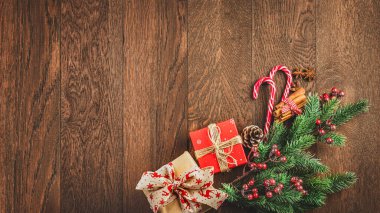Mutlu Noeller ve mutlu yıllar. Ahşap bir arka planda hediyeler, köknar dalları ve şekerler