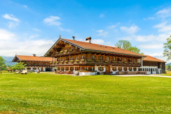 stock image Bavarian village. Traditional Bavarian wooden house, meadow and grazing horses