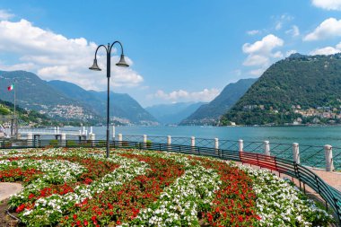 Como, İtalya. Fenerli setin manzarası ve çiçek bahçesi, göl ve dağlar.