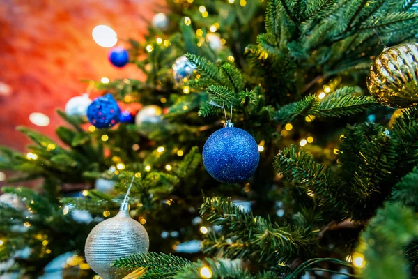 Mavi, altın toplar ve çelenklerle süslenmiş Noel ağacı