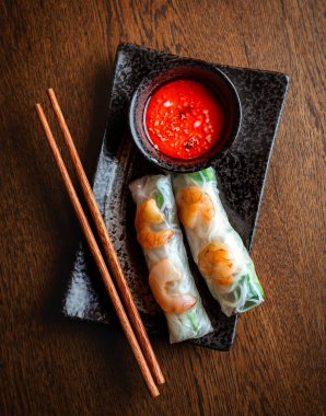 Asya mutfağı. Şeffaf pirinç kağıdı ve acı sosa sarılı karides ruloları.