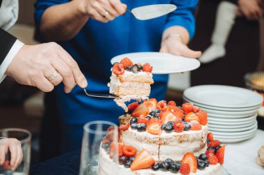 Beyaz kremalı, ahududu ve çilekle süslenmiş bir pasta.