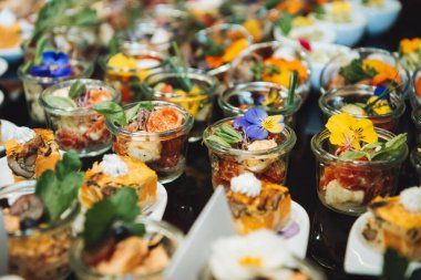 Açık büfede menekşelerle süslenmiş salatalar.