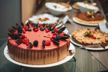 Çilekli pasta ve diğer tatlılar büyük bir masada..