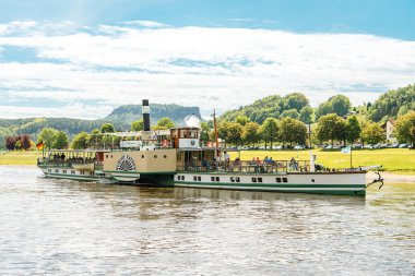 RATHEN, Saksonya, Almanya, 10 Mayıs 2025: Sakson İsviçre 'deki Rathen tatil beldesi yakınlarındaki Elbe Nehri boyunca antik bir buharlı gemi yelken açar.