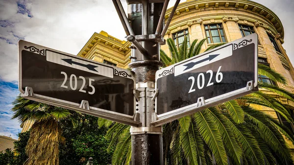 stock image An image with a signpost pointing in two different directions in German. One direction points to 2026, the other points to 2025.