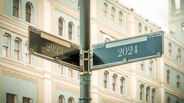 stock image An image with a signpost pointing in two different directions in German. One direction points to 2024, the other points to 2023.