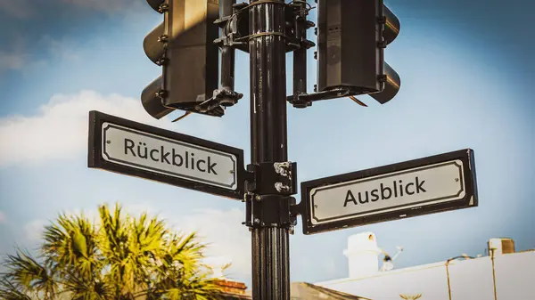 stock image An image with a signpost pointing in two different directions in German. One direction points to outlook, the other points to backsight