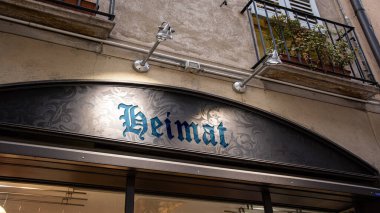 Resim bir tabela ve Almanca 'da vatan yönünü gösteren bir tabela gösteriyor..