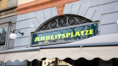 Resim Almanca işleri gösteren bir tabela ve tabela gösteriyor.