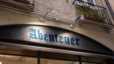 Görüntü, hayatın Almanca 'daki büyük macerasını gösteren bir tabela tasvir ediyor..