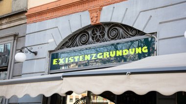 Resim, Almanca bir tabela ve bir iş kurma yönünü gösteren bir tabela gösteriyor..