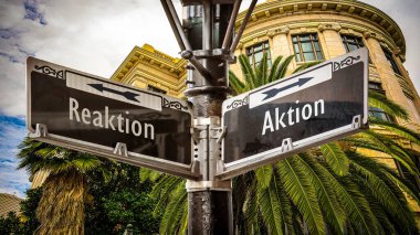 Almanca 'nın iki farklı yönünü gösteren işaret direği olan bir resim. Bir yön eylemi, diğeri tepkiyi işaret ediyor..