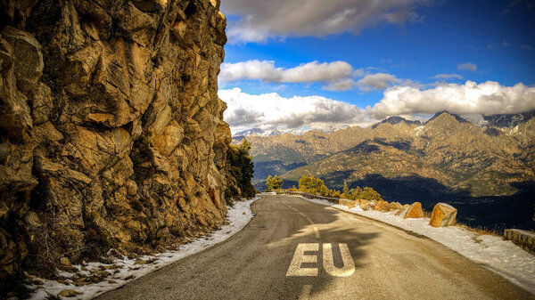 the picture shows a signpost and a sign pointing in the direction of the eu in german.