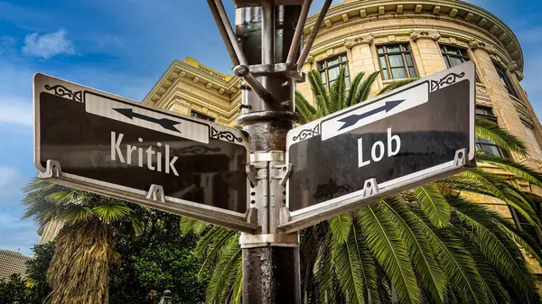 stock image An image with a signpost pointing in two different directions in German. One direction points to love, the other points to hate.