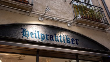 Resim, Almanca 'da Naturopath yönünü gösteren bir tabela ve tabela gösteriyor..
