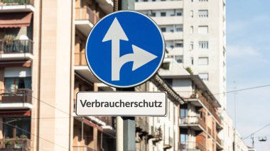 Tüketici koruması yönünü işaret eden Almanca bir işaret direği olan bir resim.